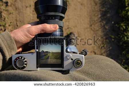 man photographer is making landscape photography with old film camera in spring or summer, tourism and hiking concept. top view. copy space