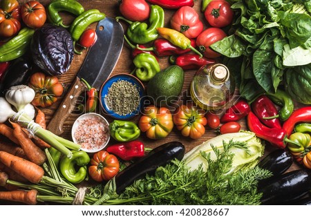 Fresh raw vegetable ingredients for healthy cooking or salad making, top view. Olive oil in bottle, spices and knife. Diet or vegetarian food concept Royalty-Free Stock Photo #420828667