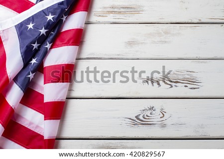 Crumpled US flag. US flag on wooden background. National banner on white floor. Unity and pride.
