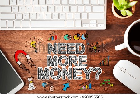 Need More Money concept with workstation on a wooden desk 