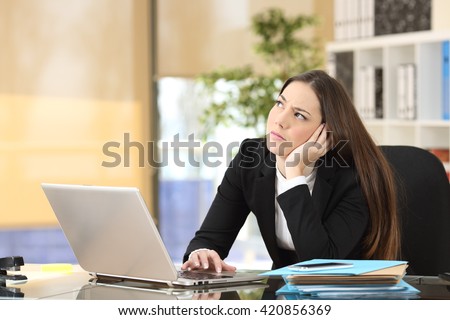 Worried pensive businesswoman looking sideways in a desktop at office Royalty-Free Stock Photo #420856369