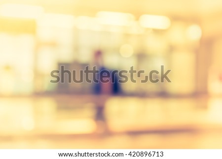 vintage tone abstract blur image of people walk in long corridor in office center for background usage .