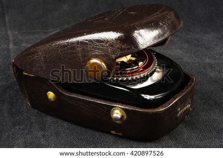 old vintage Soviet exposure meter with leather case on black background