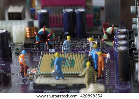 Selective focus of miniature engineer worker to fixed and repair Control Processing Unit (CPU),  mainboard computer background as technology concept.