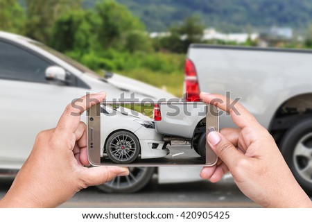 Close up hand of woman holding smartphone and take photo of car accident 