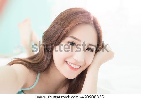 Health woman Smile take a selfie and she lying on the bed at home , asian girl