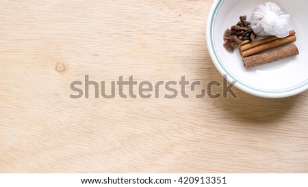 Mix of spices for soup making ingredients including coriander, fennel, cinnamon, cloves, cardamon, black pepper and star anise on wooden surface. Slightly de-focused and close-up shot. Copy space.