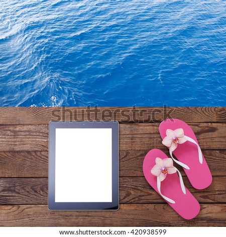 Blank empty tablet computer on beach. Trendy summer accessories on wooden background pool. Flip-flops on beach. Tropical flower orchid. Flat mock up for design. Top view. square