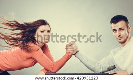 Partnership relationship concept. Girlfriend confronts his boyfriend. Woman and man arm wrestling challenge between young couple