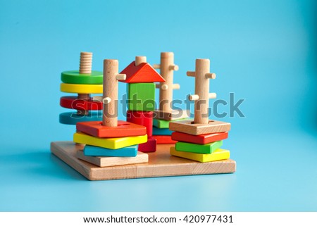 Colorful wooden toy building blocks with toys on a blue background