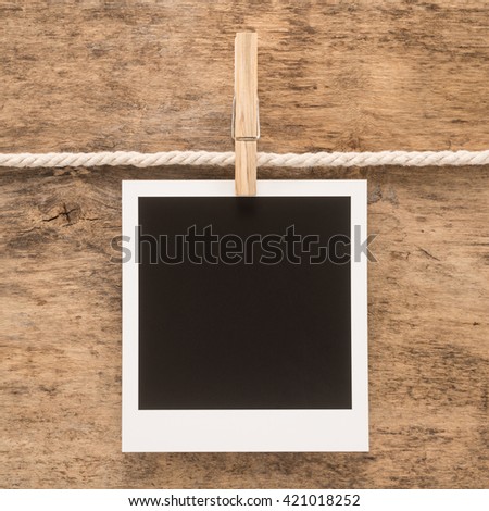 Blank retro photo frame on wooden background
