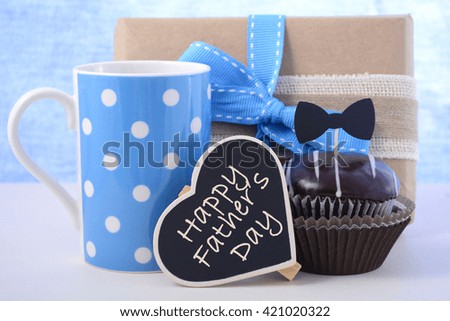 Happy Fathers Day cupcake gift on pale blue and white wood background. 