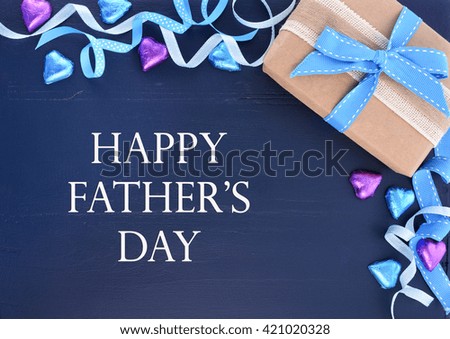 Happy Fathers Day background on dark blue distressed wood table with decorated borders.