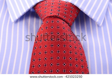 Fathers Day concept with closeup of red mens tie and blue and white stripe shirt business man's attire. 