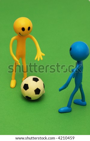 Two smilies playing  football on green pitch