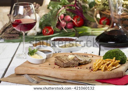 Grilled Steak Slice with french fries on rustic wood table