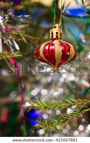 Beautiful striped Christmas ball on the tree branches.