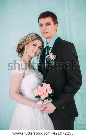 Happy couple. Wedding photo shoot in the white studio with wedding decor kisses, hugs. Classic portrait