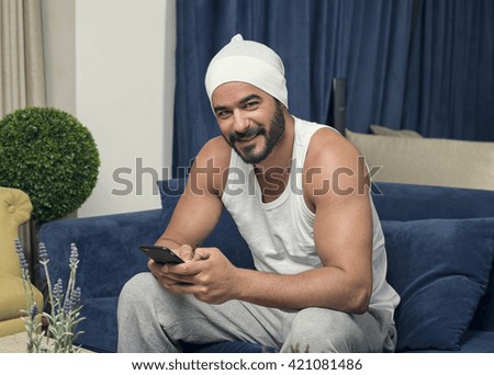 Handsome guy using smartphone, Handsome man sitting on couch at home and using smartphone 