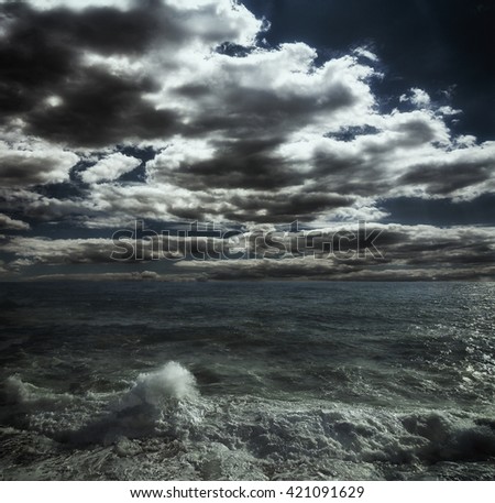 Dark storm clouds and huge waves on a sea