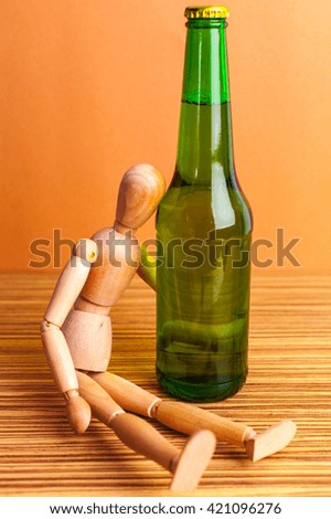 Alcoholism concept. Wooden doll with Alcohol drink