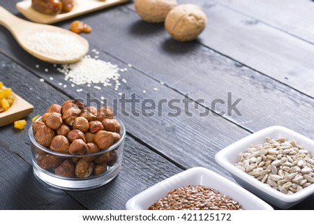 sun dried super foods, nuts and seeds, frame on black wood table background