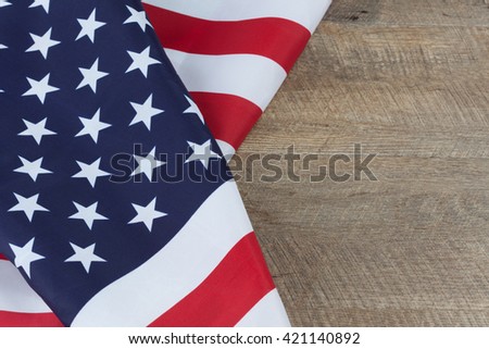 American flag folds on walnut wooden table. Horizontal image with copy space