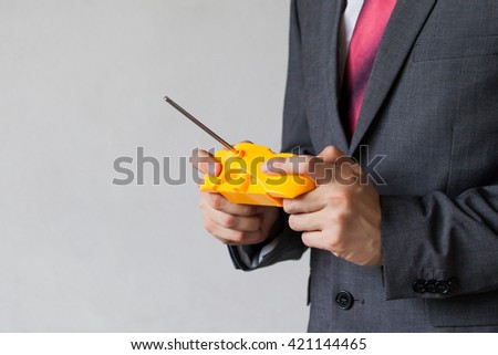 Business man holding a joystick - manipulation, controlling, entertainment concept