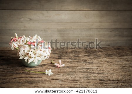 Vintage fresh flower in vase on old wood table