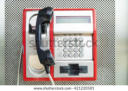 red payphone on a city street Royalty-Free Stock Photo #421220581