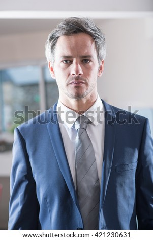 Portrait of a man preparing to go to an important appointment, he is looking at the mirror checking last details