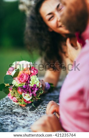 Close up portrait of attractive young couple in outdoor park near old castle. Man with beard, woman with curly hair.