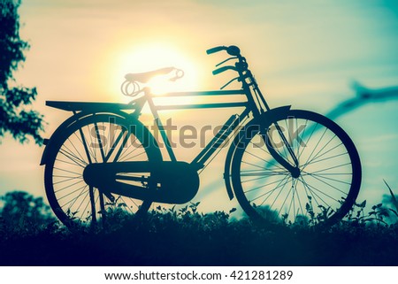 beautiful landscape image with Silhouette Bicycle at sunset in vintage tone style
