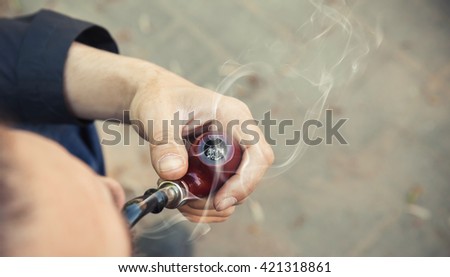 Man smoking pipe, outdoor photo with selective focus and vintage tonal correction photo filter, instagram old style effect