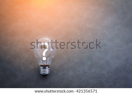 bulb with question mark on grey color background Royalty-Free Stock Photo #421356571