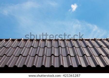 Dark brown roof tile with blue sky.