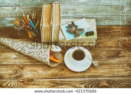 Cup of coffee and flowers on a wooden table on a wooden background. Vintage or retro tone