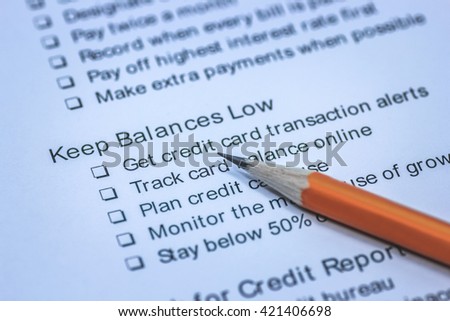 Credit rating discipline concept, macro view of pencil with checklist of keep balance low, credit card transaction alerts, track balance online, credit report