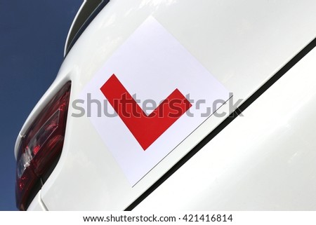 magnetic British L-plate affixed to the back of a white car