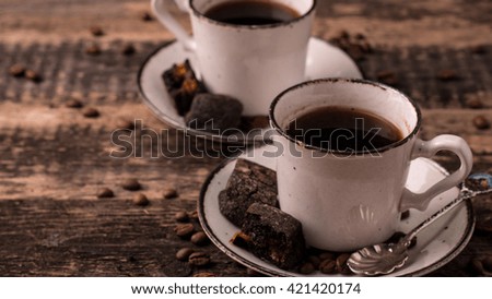 Cup of coffee with coffee beans on a wood table, close up photo