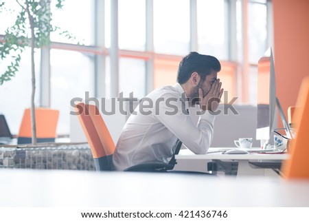 frustrated young business man working on desktop  computer at modern startup office interior Royalty-Free Stock Photo #421436746