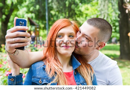 Young couple in a Park taking picture of themselves