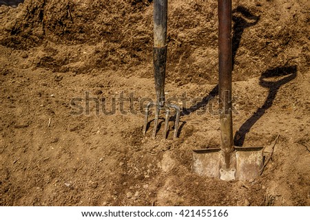 Shovel pitchfork  in black soil