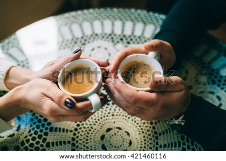 hands wrapped around a cups of coffee