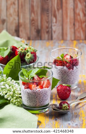 Homemade pink Chia pudding with  fresh strawberries on wooden table. Selective focus