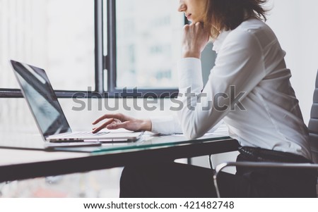Working Process in Modern Office. Young Woman Account Manager Working at Wood Table with New Business Project. Typing keyboard,Using Contemporary Laptop. Horizontal. Film effect. Blurred background.