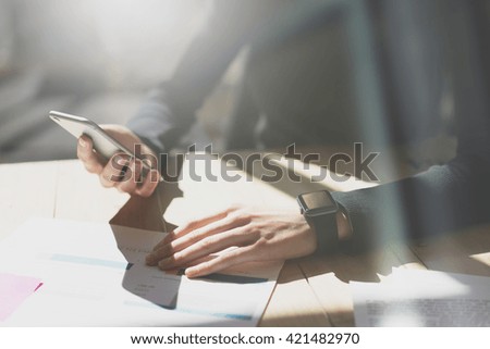 Photo Woman Working Modern Office.Girl Wearing Generic Design Smart Watch.Female holding smartphone hands. Account Manager Work Process at Wood Table.Horizontal mockup.Burred Background. Film effect.