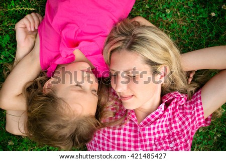 Smiling mother and little daughter on nature. Happy people outdoors
two amazing girls have a rest on nature