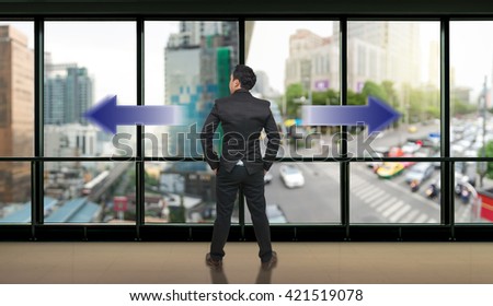 Businessman standing in doubt,thinking the two different choices of transportation for traffic jam with rush hour which indicated by arrows pointing in opposite direction, business decision concept