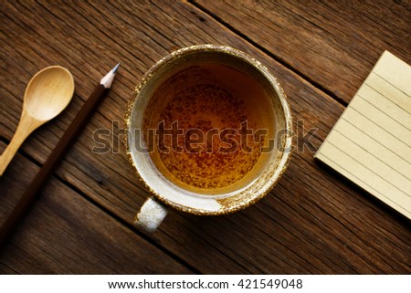 still life tea cup with notebook on wooden table background.flat lay.(selective focus)